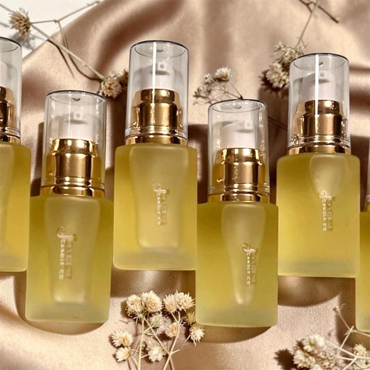 Set of skincare bottles with gold caps on a beige background with flowers.