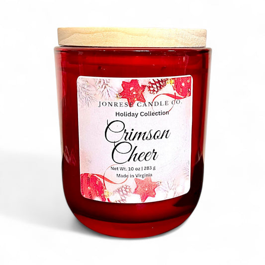 Red candle with a decorative label with the name "Crimson Cheer' on a white background