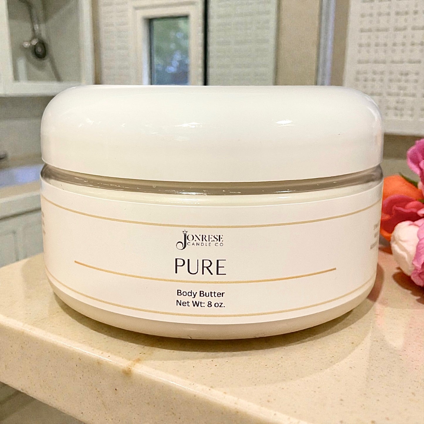 White jar of Jonrese Pure Body Butter on a bathroom counter