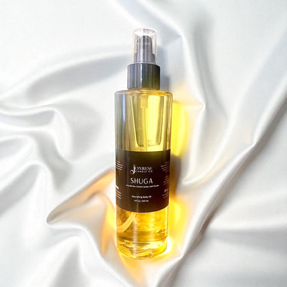 Bottle of Shuga body oil on a white satin background